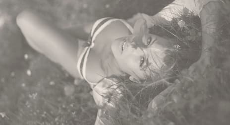 Dame med undertøy liggende på gress