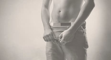 Mann knepper opp bukse