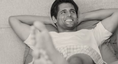 smilende mann med armene bak hodet