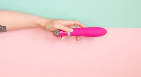 kvinne holder vibrator i hånden