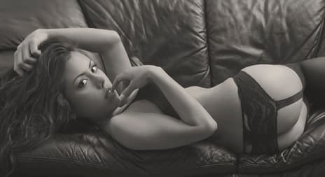 jente ligger forførende på skinnsofa i blondeundertøy - erotisk novelle - Aller best med den du elsker - illustrasjonsfoto, Shutterstock